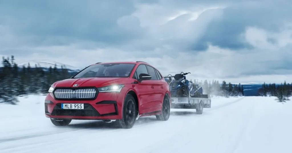 Red Skoda Enyaq travelling on a snowy road